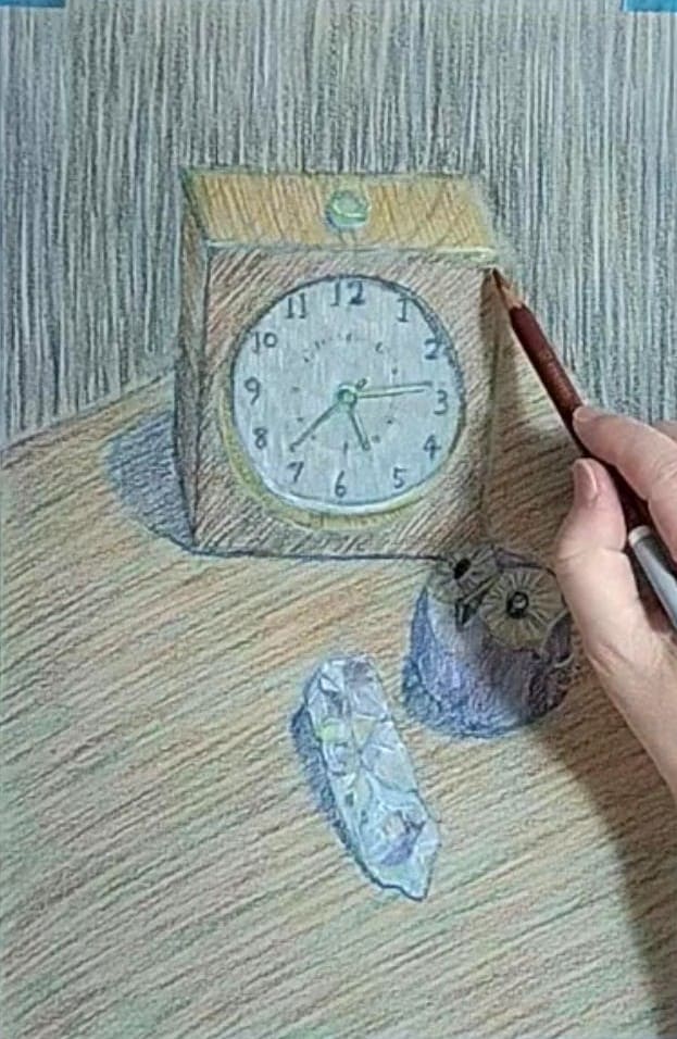 パステル色鉛筆で時計の消した箇所を描いている様子