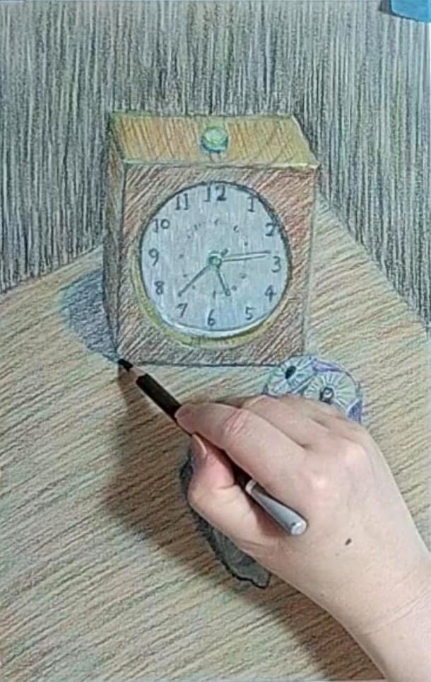 時計の机との接地面を描いている様子