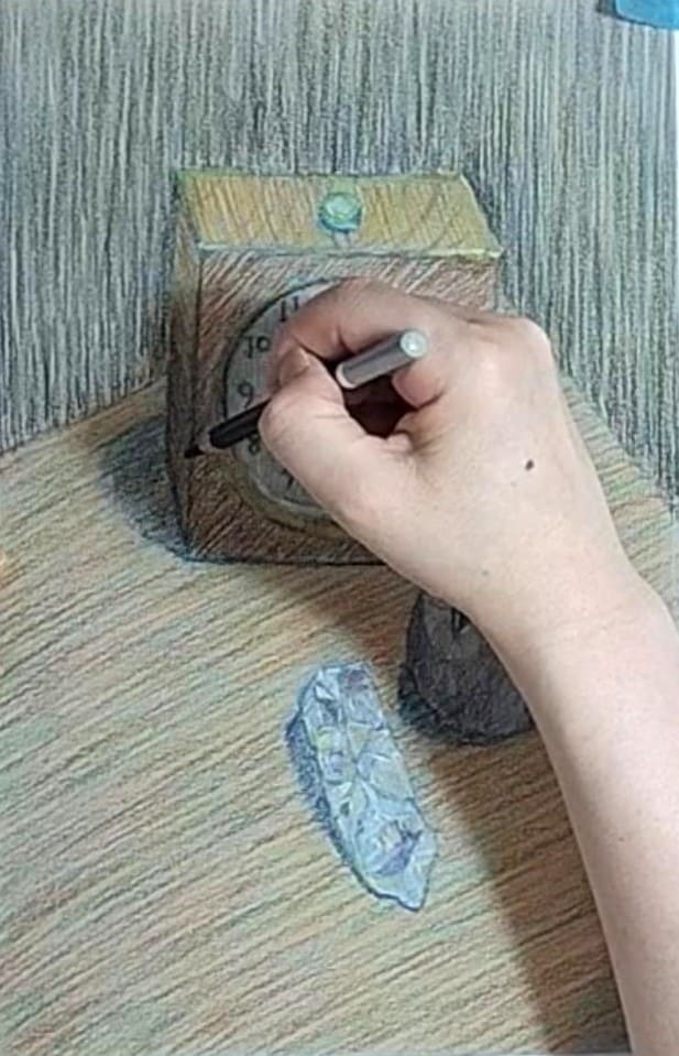 時計の影をハッチングで重ねて描いている様子