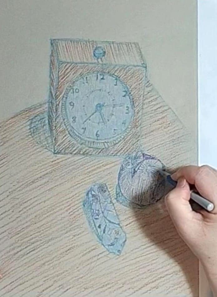 水色のパステル色鉛筆でフクロウの置物の明るい部分をハッチングで描いている様子